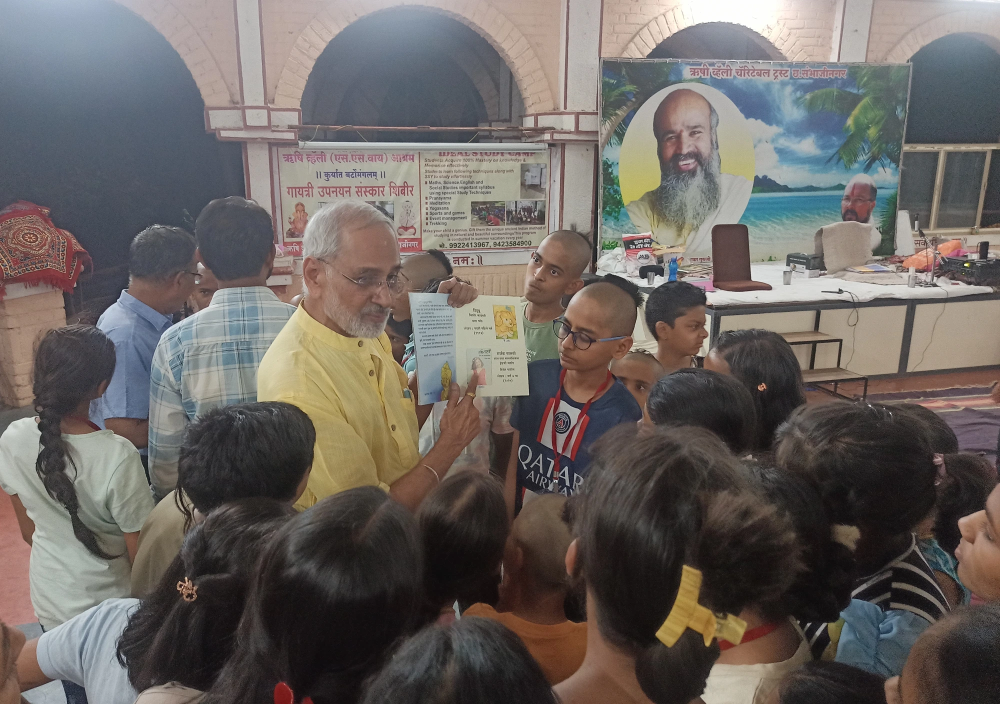 Baba Bhand sir sharing a book with children at the shibir